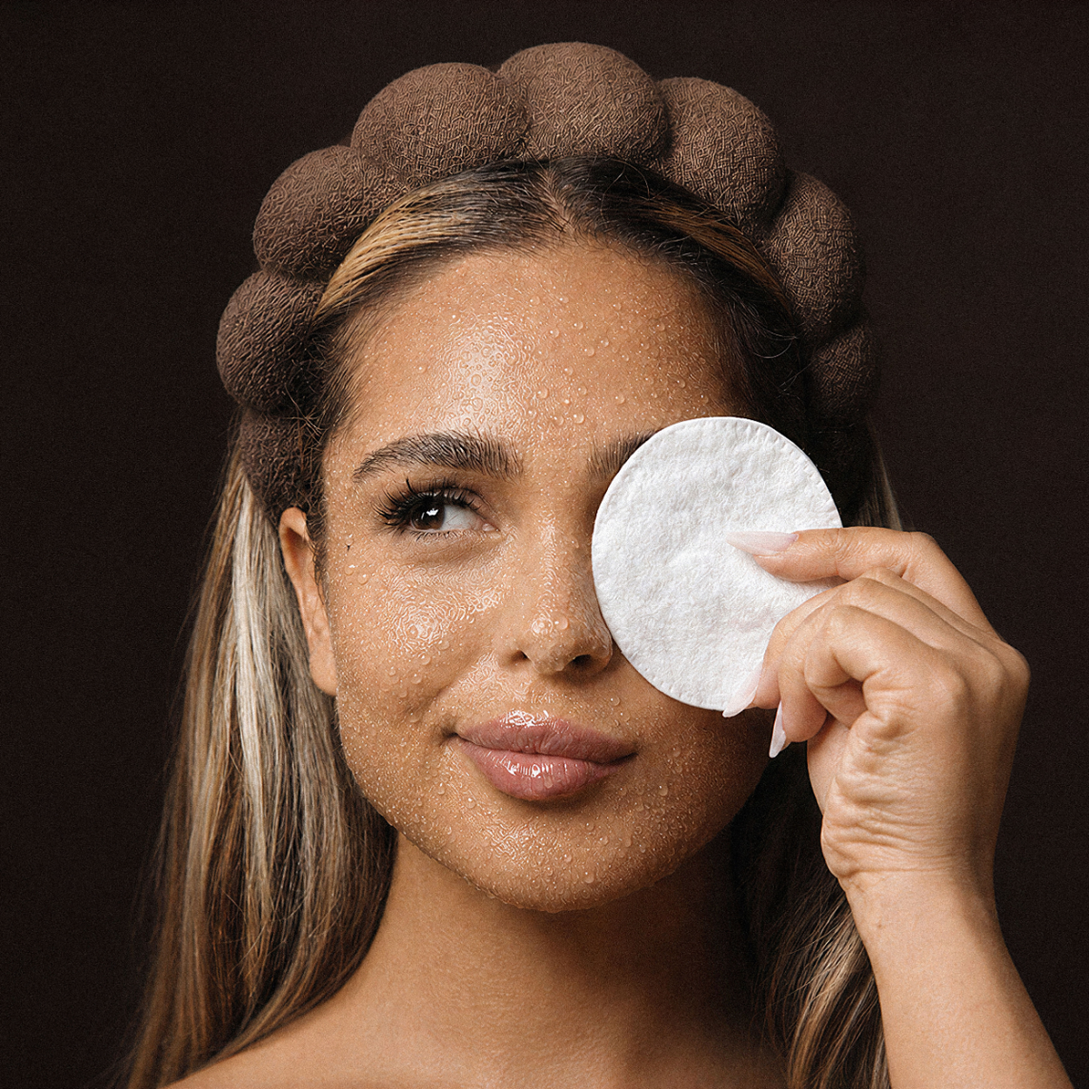 Femeie demachiindu-se cu apă micelară Natural Beauty by Laura Baldini, folosind un disc din bumbac