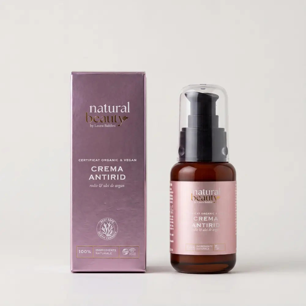 Cutia mov și flaconul Cremei Antirid Natural Beauty by Laura Baldini, cu rodie și ulei de argan, pe fundal neutru.
