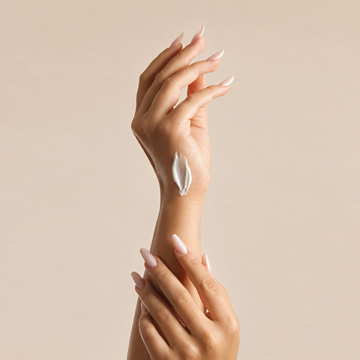 Cremă albă aplicată pe dosul palmei, mâini încrucișate, pentru Crema de Mâini Nutritivă Natural Beauty by Laura Baldini