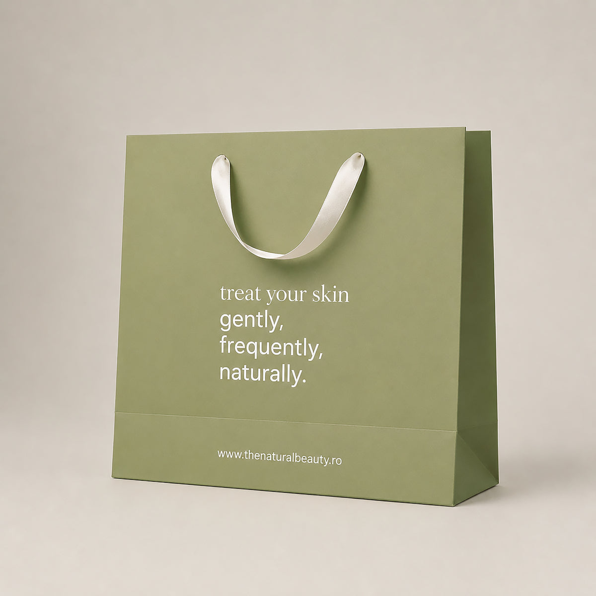 Plasă cadou Natural Beauty verde-olive cu mânere din panglică crem și mesajul „treat your skin gently, frequently, naturally.”